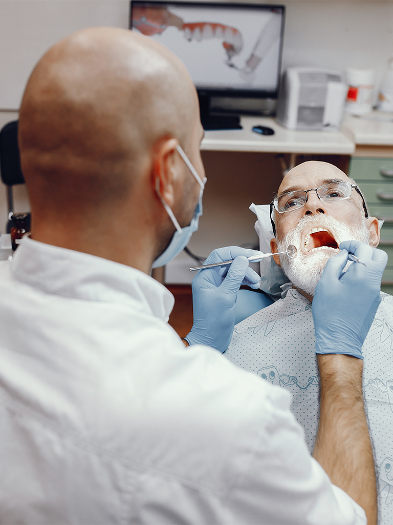 Dr. Vihang Sukhadia performing an oral cancer diagnosis at Sukriti Hospital in Bharuch. Advanced diagnostic tools for early detection of oral cancer.